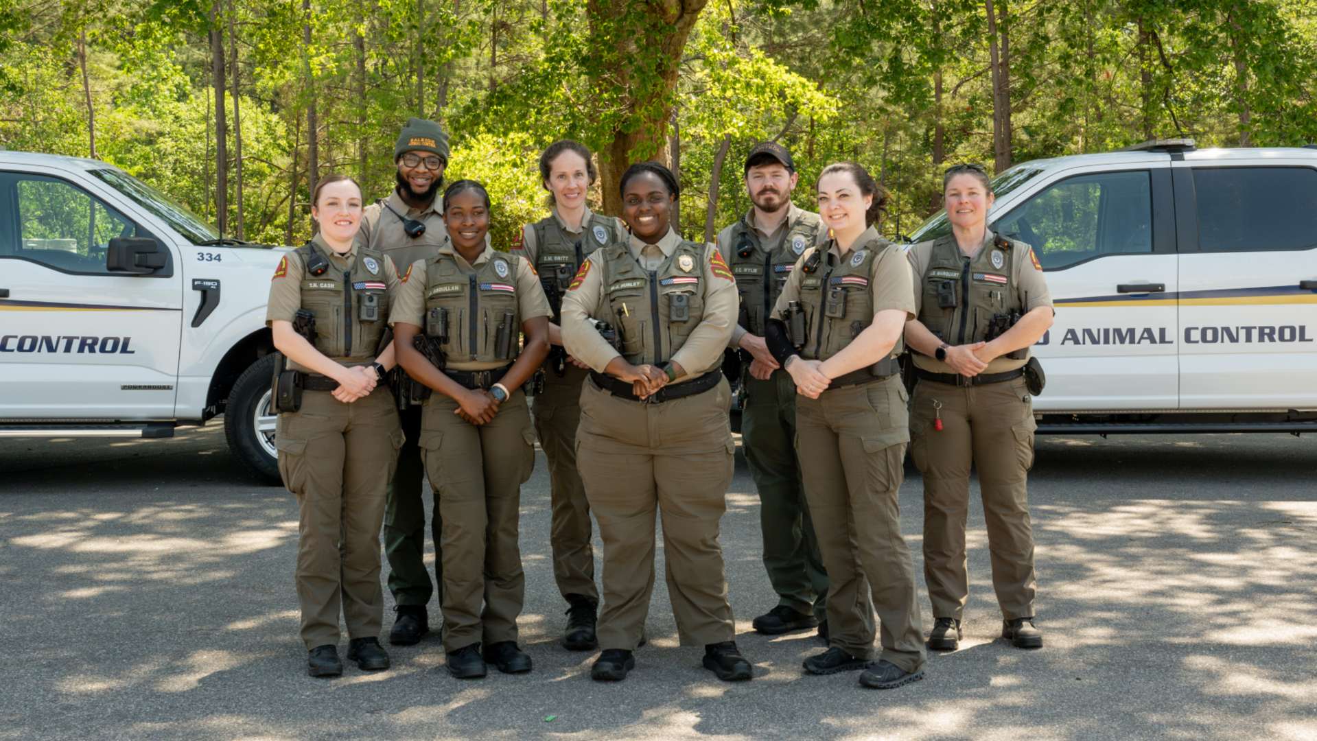 Animal Control officers standing in front of their vehicles