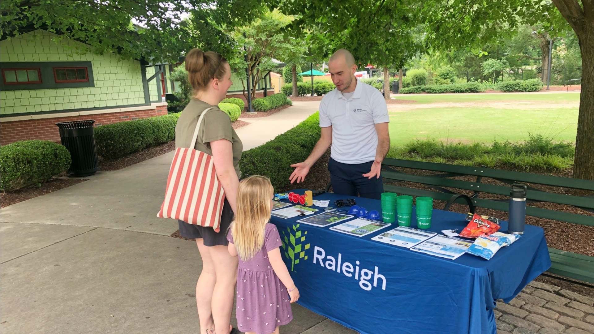 Woman and child talking to man at event table