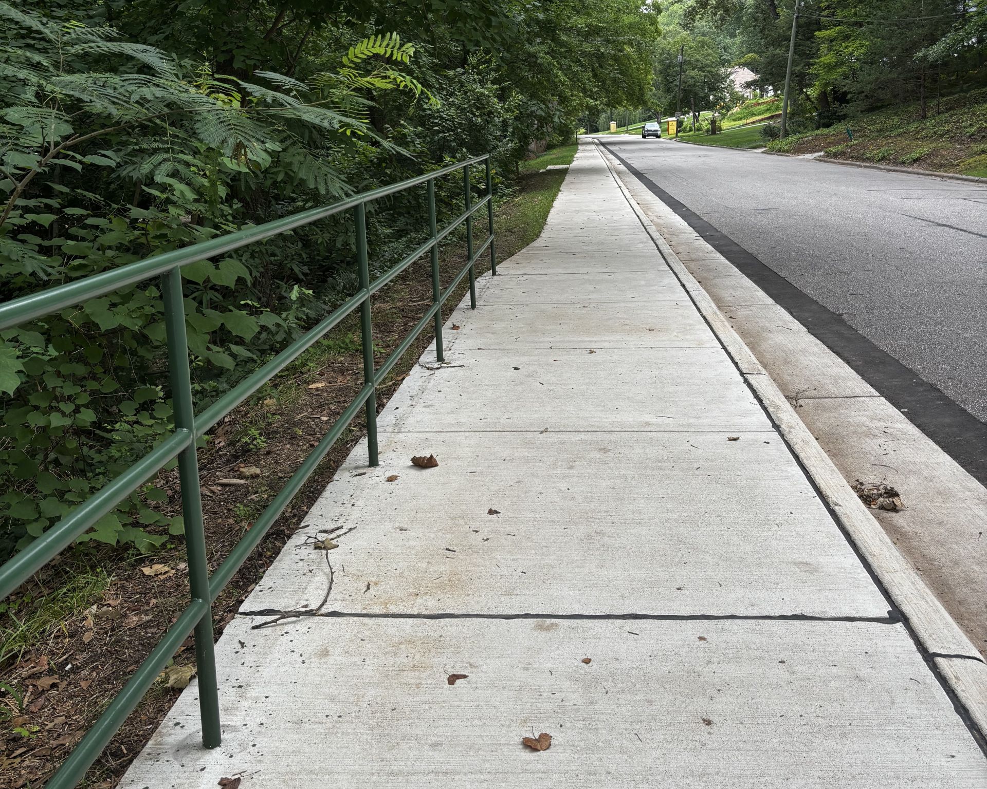 sidewalk with green rail