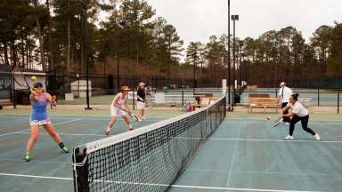 Women batting the ball back and forth at Millbrook Exchange Tennis courts