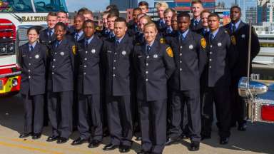 Firefighters wearing dress uniform standing in rows