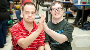 Two Specialized Recreation Program participants give each other a high five.