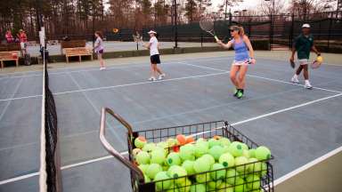Women hitting tennis balls on tennis courts