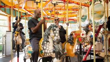 View of people riding the John Chavis Memorial Park historic carousel