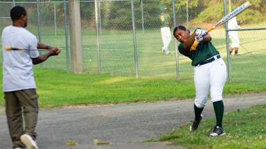 Girl swinging at bat during RBI police league practice