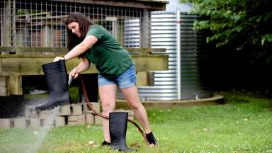 A woman cleaning boots using water from a cistern