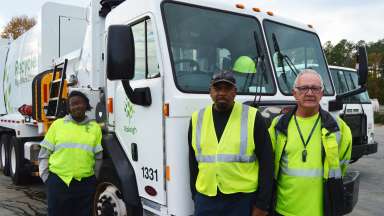 two male and one female recycling crew employees in front of the truck