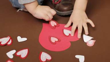 Kid hands doing Valentine's Day crafts