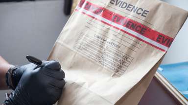 Man writing in black sharpie on an evidence bag