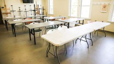 A classroom with tables, chairs and easels