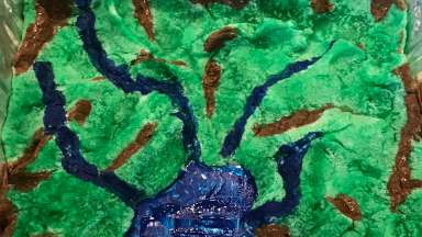 A green, brown, and blue watershed model made from clay