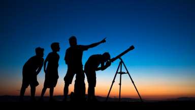 Group of people stargazng with telescope