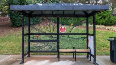 artwork by Leslie Bartlebaugh covering the windows of a bus shelter