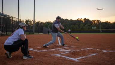 Batter hitting ball on base with catcher behind