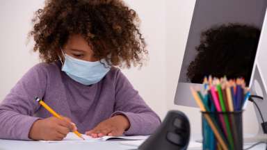 Girl wearing mask doing school work