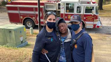 Firefighters with woman in community they helped