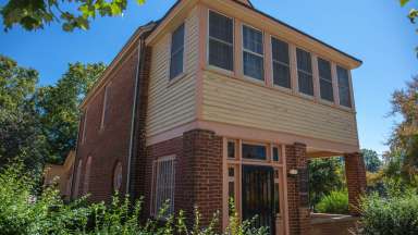 The exterior of the Pope House Museum surrounded by green trees
