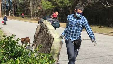 Two volunteers carrying a mattress that was cleaned up from a stream in Raleigh.