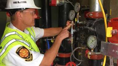 fire inspector checking gauges on some pipes