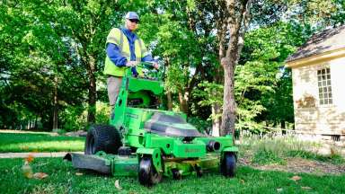 Man on electric grass mower