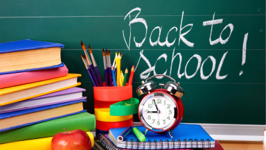 Books, block, notebooks, apple, pencils and paintbrushes in front of chalkboard that has "Back To School!" written on it