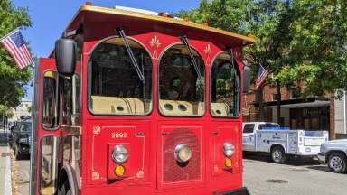 Historic red trolley parked on street in downtown