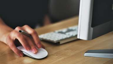Online Appointments - Woman's hand on mouse in front of computer