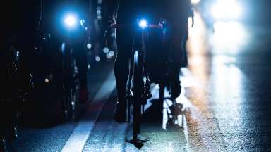 Bicycles with front lights riding on a road at night