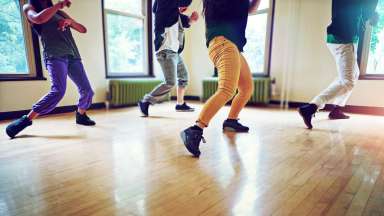 Cropped shot of a group of people dancing together in a studio