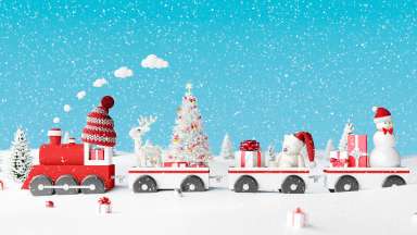 Toy train with winter background, presents, and snowman in Santa hat