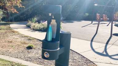 water bottle on fountain filling station with playground in background