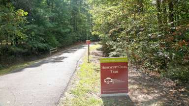 Entrance to Honeycutt Creek Greenway Trail with trees on either side