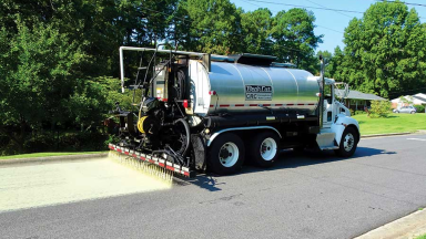 Truck applying titanium dioxide coating to roadway