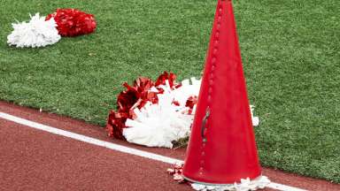 Image of a meagphone and pom poms on the ground on a track