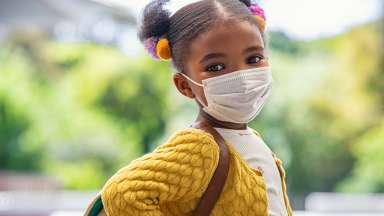 Girl with a mask and a yellow shirt