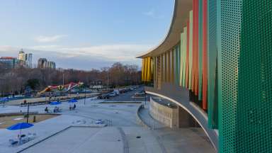 View of the colorful front of John Chavis Community Center over looking picnic area and splash pad.