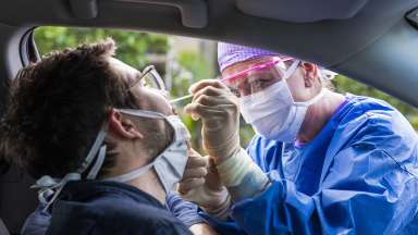 Nurse takes nasal swab of driver