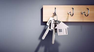 Key ring with a house-shaped keychain hangs on hook