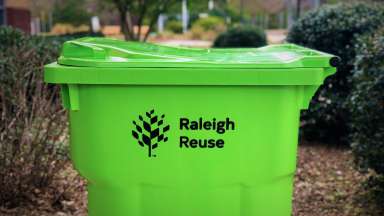 bright green yard waste container with the words "Raleigh Reuse" heat-stamped on the side.