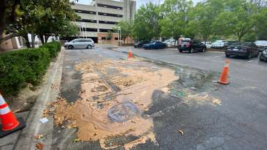 An overflow from a manhole in the parking lot of fats, oils, and grease that clogged the sewer system.