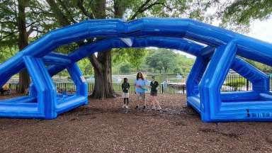 An inflatable blue arch with people standing under it