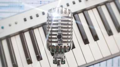 Vintage microphone in front of piano keys
