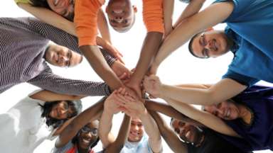 Teens in a huddle smiling