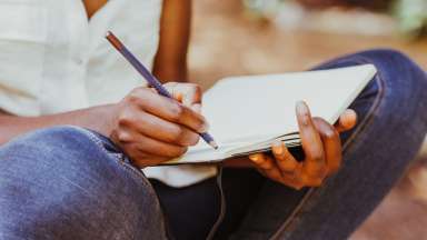 person writing in journal