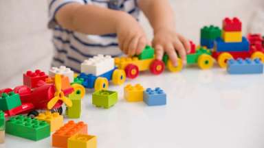 a boy playing with a Lego train