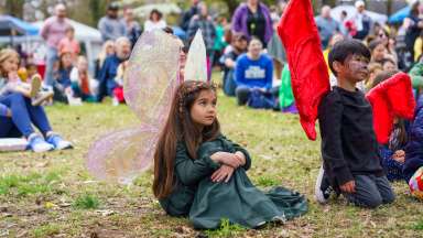 young children wearing fairy wings sitting on grass