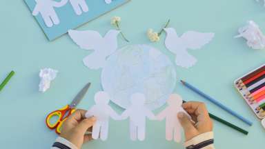 image of child hands doing crafts with paper people cut-outs