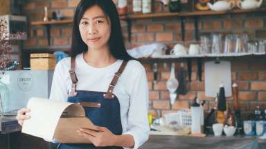 woman-wearing-apron-and-holding-clipboard