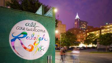 mural-at-night-saying-all-are-welcome-raleigh