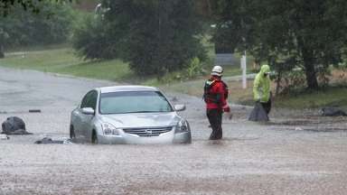 Car stuck in flooded roadway